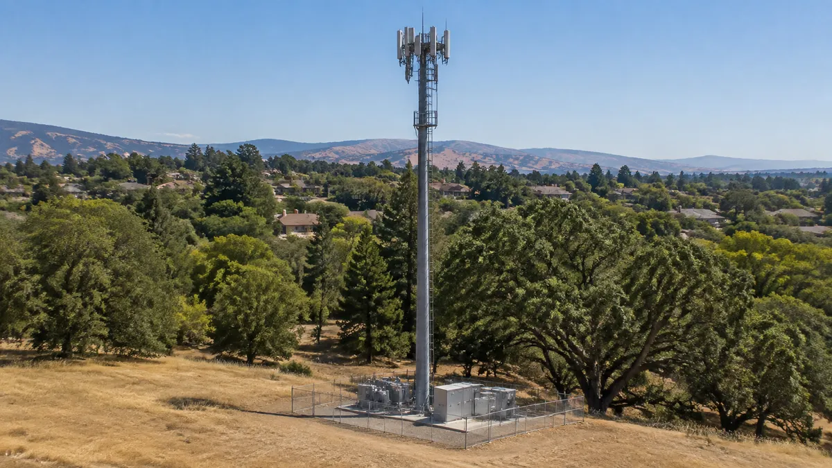 AI-generated scene of a cellular monopole beside oak trees and dry grass.